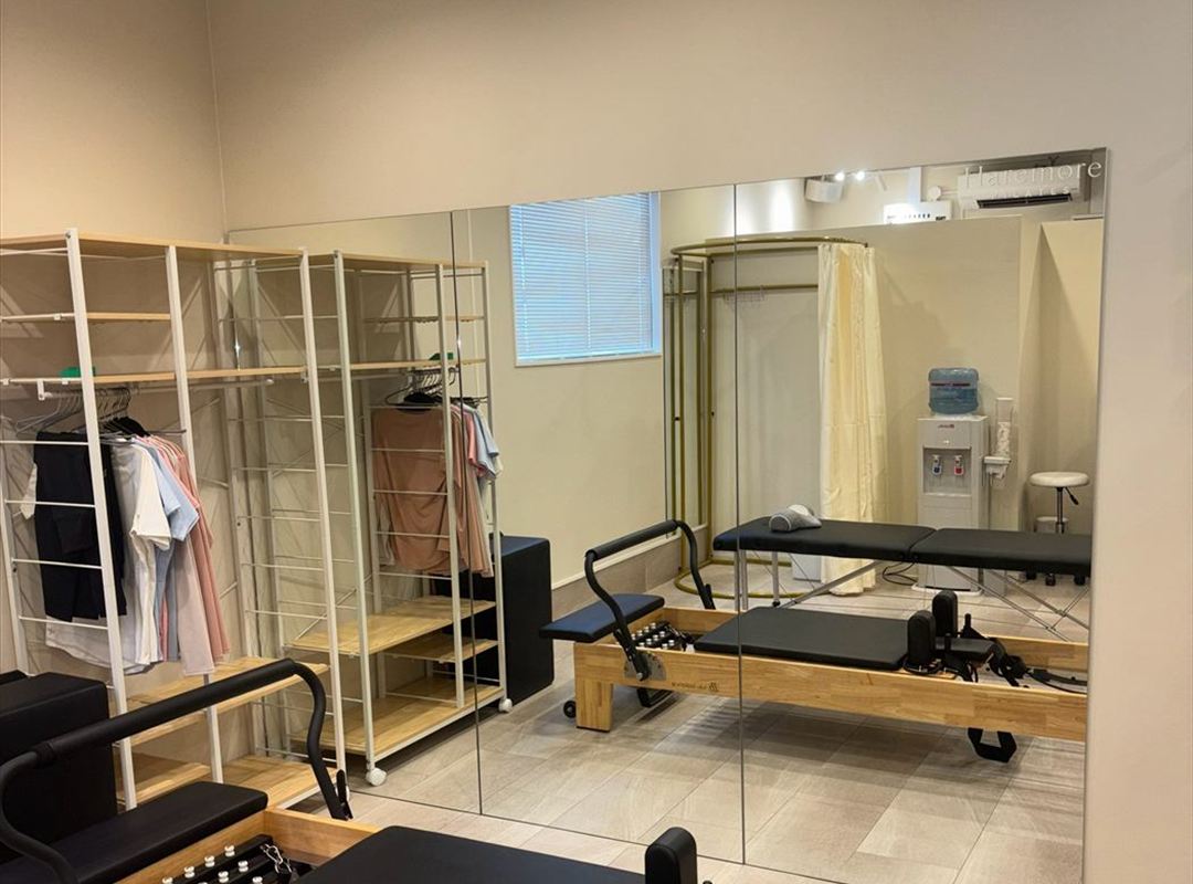 倉敷市北浜町のHaremore Pilatesスタジオ内観。リフォーマーと鏡、レンタルウェアの棚